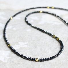 I take a pride in featuring the finest black diamonds (beads) in the market. These diamonds not only radiate an intense sparkle but are also believed to bring powerful protective energy, making the necklace a blend of beauty and potential healing benefits. All the gold beads used in this necklace are made of heavy-weight 14K solid gold, each one literally a chunk of small, pure gold with no hollow interior. Faceted black diamond Approximately 10.1 carats 1.7mm~2.2mm 14K solid gold beads 14K solid gold clasp 【Threads about diamond necklace】 Due to the small size of the holes in these black diamonds, only a thin thread can pass through. Although I use high-quality, durable nylon-coated stainless steel thread, it is advisable to avoid hooking or pulling to maintain the integrity of the jewelr Diamond Necklace Choker, Edgy Necklace, Spinel Jewelry, Protective Energy, Black Diamond Necklace, Black Diamond Solitaire, Dainty Diamond Necklace, Silver Diamond Necklace, Layered Chokers