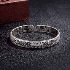 "This splendid Buddhist Lotus Flower & Heart Sutra bangle bracelet is carefully handmade with S990 Silver. It depicts a blooming Lotus symbol of blissful liberation and purity in Buddhism. The Buddhist Heart Sutra is a beautifully carved on the inside of the bracelet and meant to bring love and compassion. The bangle is adjustable to your wrist size. In Buddhism, the lotus flower is known as the \"flower of heaven.\" It is said that it stands for four essential virtues, which are loveliness, sof Luxury Spiritual Sterling Silver Bracelet As Gift, Luxury Spiritual Sterling Silver Bracelet, Luxury Sterling Silver Spiritual Bracelet, Buddhist Lotus Flower, Buddhist Lotus, Lotus Bangle, Rose Gold Anklet, Lotus Symbol, Bracelet For Him