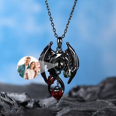 This is a mysterious necklace, personalized for the moment you love most on a projection necklace! Beautifully handcrafted in sterling silver, this necklace features a personalized photo projection stone guarded by a dragon. His 3D wings, ears, and bright green eyes are captured in amazing detail as he is on your neck. Hide your photo in the necklace, you can see the photo inside the necklace, or you can use it to illuminate the light and project your photo on the wall. This customized projectio Personalized Black Pendant Jewelry, Black Pendant Jewelry For Personalized Gift, Personalized Black Pendant Necklace, Black Pendant Necklace For Personalized Gift, Black Round Pendant Necklace For Personalized Gift, Dragon Design Round Pendant Necklace As A Gift, Dragon Design Round Pendant Necklace For Gift, Black Pendant Necklace For Anniversary Gift, Black Dragon Design Jewelry Gift