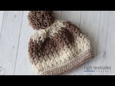 a brown and white knitted hat laying on top of a wooden floor