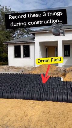 there is a drain in front of a house with a sign that says record these 3 things during construction