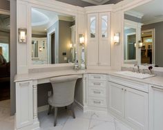 a large bathroom with white cabinets and marble counter tops, along with an oval sink