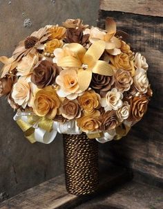 the bridal bouquet is made with paper flowers and ribbon, along with gold ribbons