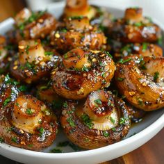 a white bowl filled with cooked mushrooms covered in seasoning