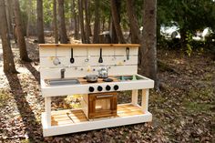 an old fashioned stove in the woods with pots and pans on it's burners