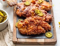 fried chicken with pickles on a cutting board