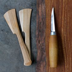 two wooden knives are next to each other on a table