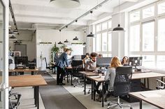 an office with people working at desks and computers in it royalty - fotor