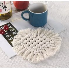 a white mop sitting on top of a table next to a cup