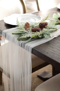 the table is decorated with pine cones and greenery