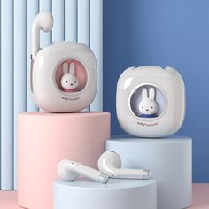 two bunny earbuds sitting on top of each other in front of a blue wall