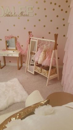 a pink and gold girls'bedroom with polka dot wallpaper