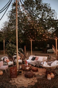 an outdoor seating area is decorated with lights and wicker furniture, including two sofas