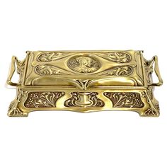 an ornately decorated gold box on a white background