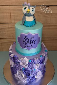 a blue and purple cake with an owl on top that says sweet baby bleu