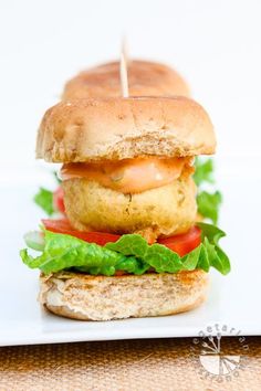 a close up of a sandwich on a plate with lettuce and tomato slices