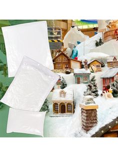 there are many small houses and trees in the snow covered town with white sheets on them