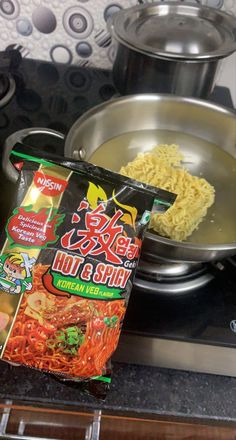 a bag of noodles sitting on top of a stove next to a frying pan