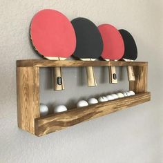 three ping pong paddles mounted to a wooden rack