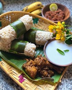 some food is sitting on a plate with bananas and other foods in bowls around it