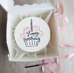 a birthday cake in a box with pink ribbon on the side and happy birthday written on it