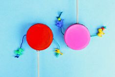 two round lollipops on a blue background with small toy animals around them