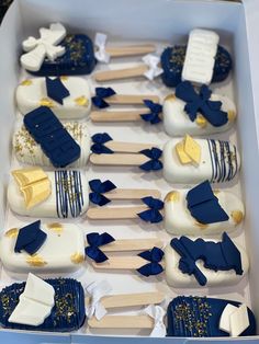 a box filled with lots of blue and white cupcakes