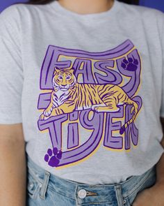 Tiger fans all around wherever you are need this fun Easy Tiger Retro graphic. We made this shirt with you in mind as your go-to t-shirt. This t-shirt is a fun way to cheer on your tiger. Cotton/Poly/RayonUnisexHeather White Sizing: S M L XL 2XL 2/4 6/8 10/12 14/16 16/18 Pom Squad, Pta Membership, School Shirt Designs, Camp Shirts, Easy Tiger, Student Council, Spirit Wear, Heather White, Retro Shirts