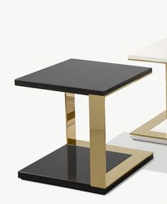 two black and gold side tables with one on each side, the other off to the side