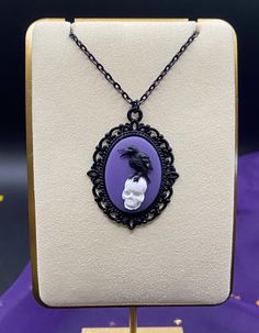 Black and purple resin Raven on skull cameo. Cameo (without tray) measures 18x25mm, please see pics for coin comparison. Chain is metal alloy and 18 inches in length. Raven On Skull, Skull Cameo, Purple Resin, Cameo Necklace, Black And Purple, Violet, Jewelry Necklaces, Necklaces, Chain