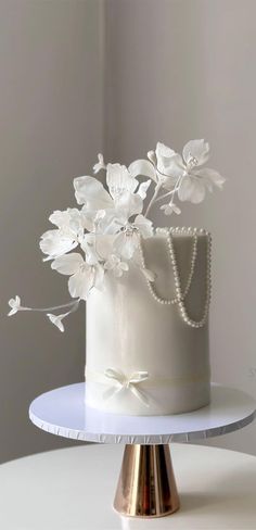 a white wedding cake decorated with flowers and pearls