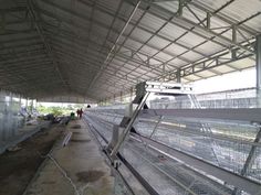 the inside of a building with several cages on each side and people walking around it