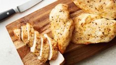 sliced chicken on a cutting board next to a knife