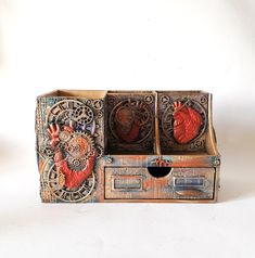 an old wooden box with two heart shaped decorations on the front and inside, sitting on a white surface