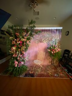 a chair sitting on top of a wooden floor in front of a wall covered with flowers