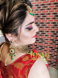 a woman in a red and gold dress with jewelry on her neck, wearing a head piece