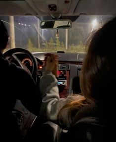 two people in a car driving at night