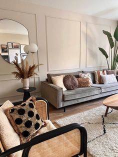 a living room filled with furniture and a large mirror on the wall above it's headboard