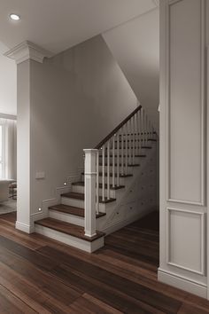 an empty room with wooden floors and stairs