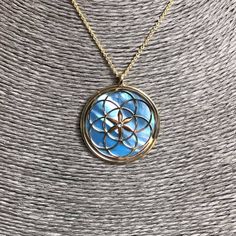 "Seed of Life pendant 24 carat gold plated on 925 Silver, blue mother of pearl and crystal. The symbol commonly referred to as the Seed of Life is made up of seven circles; one in the center, and six others placed around it according to ancient spiritual traditions. It's tought that the seven interlocking circe are compared to the seven days of creation, with the different circles being ascribed to different points in the universe's making. The flore blooming in the middle is considered the Cons Seven Days Of Creation, Crystal Spiritual, Seed Of Life, Mother Pearl, Sacred Geometry, Silver Blue, Rose Gold Plates, Mother Of Pearl, Geometry