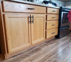 a kitchen with wooden cabinets and stainless steel appliance on the counter top, next to an oven