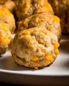 several biscuits with cheese on them sitting on a plate