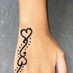 a woman's hand with a tattoo on it that has a heart in the middle