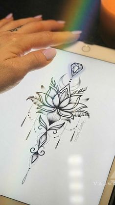 a woman's hand holding an ipad with a tattoo design on it