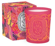 an orange and pink candle in front of a box with the label da sace on it