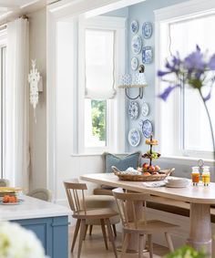 a dining room with blue and white plates hanging on the wall next to a table