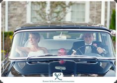 the bride and groom are driving in their wedding car