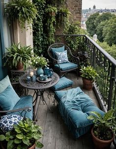 an outdoor patio with blue cushions and potted plants on the balcony, surrounded by greenery