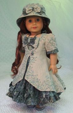 a doll with long hair wearing a dress and hat