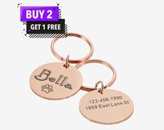 two personalized metal key chains with the name and dog's paw on them